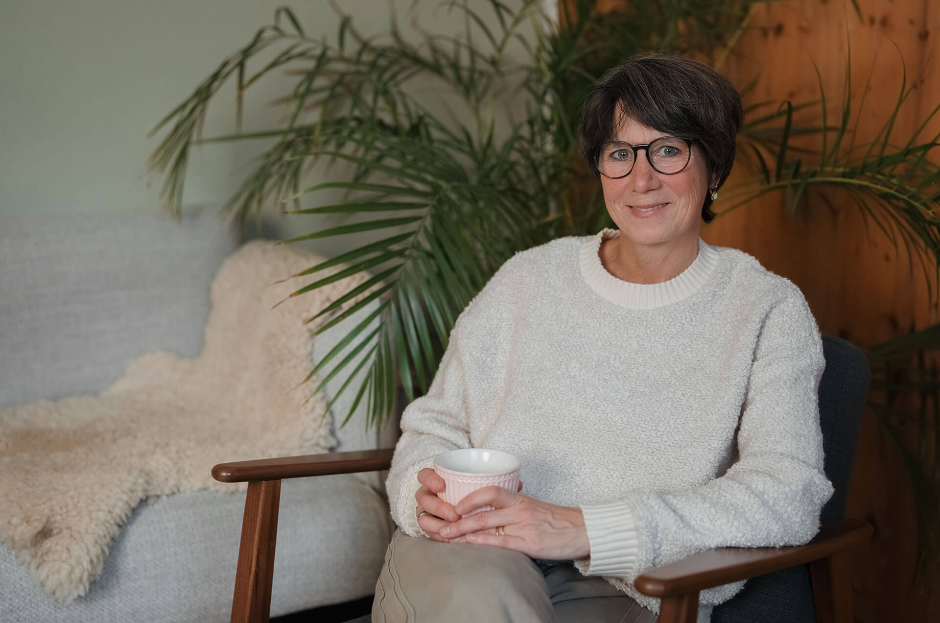 Astrid Boden sitzend auf einem Sessel in ihrer Praxis