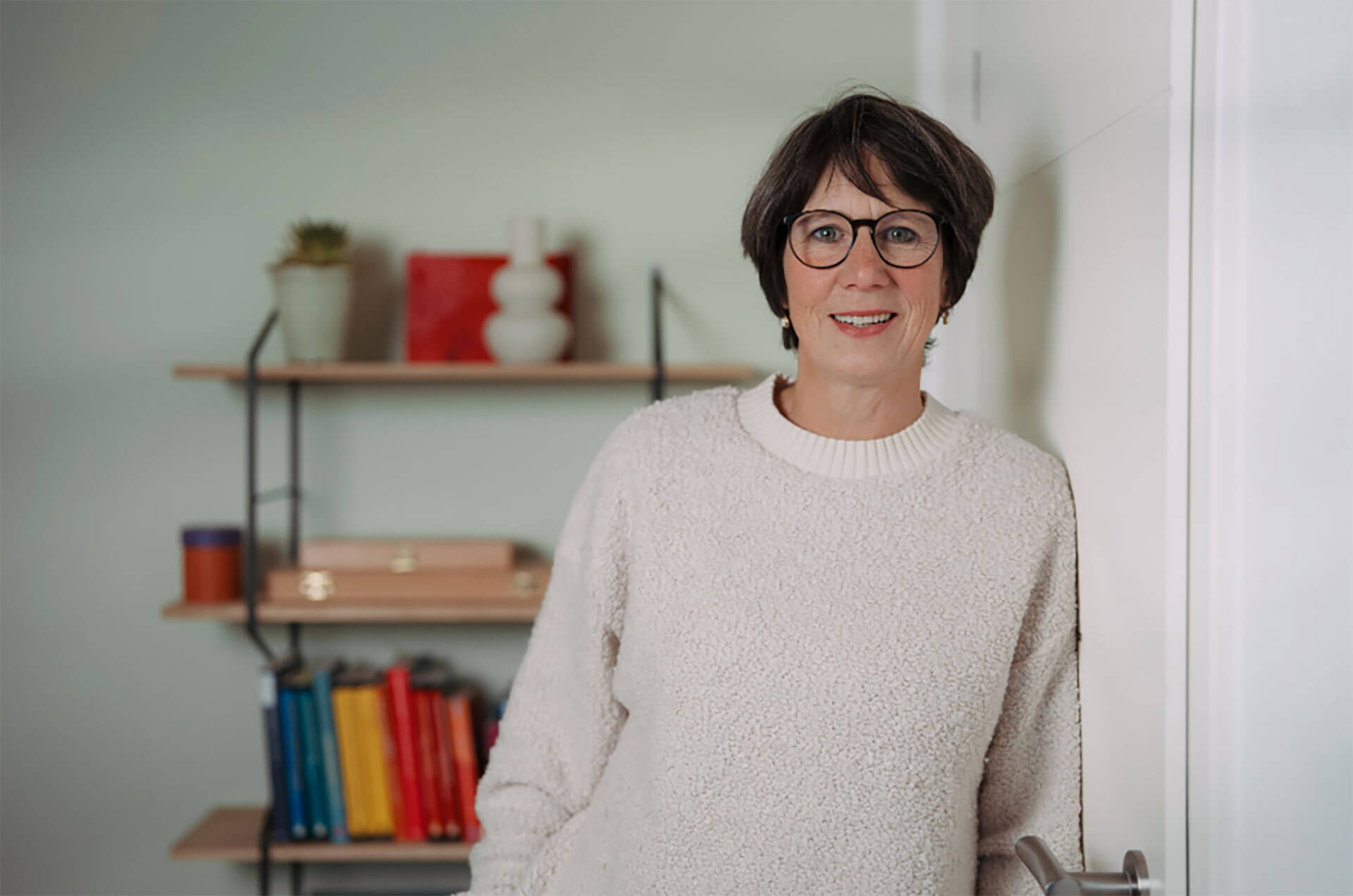 Astrid Boden an der Wand gelehnt in ihrer Praxis